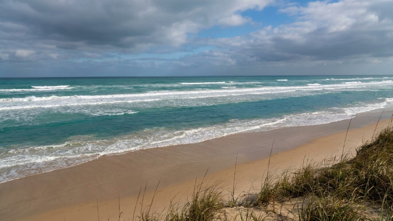 Gulf surf showing wave patterns and calm channel indicating rip current location