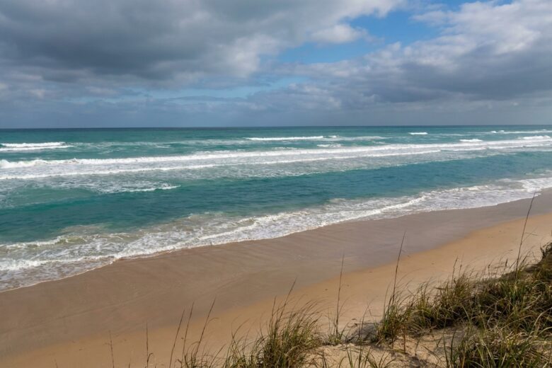 Gulf surf showing wave patterns and calm channel indicating rip current location